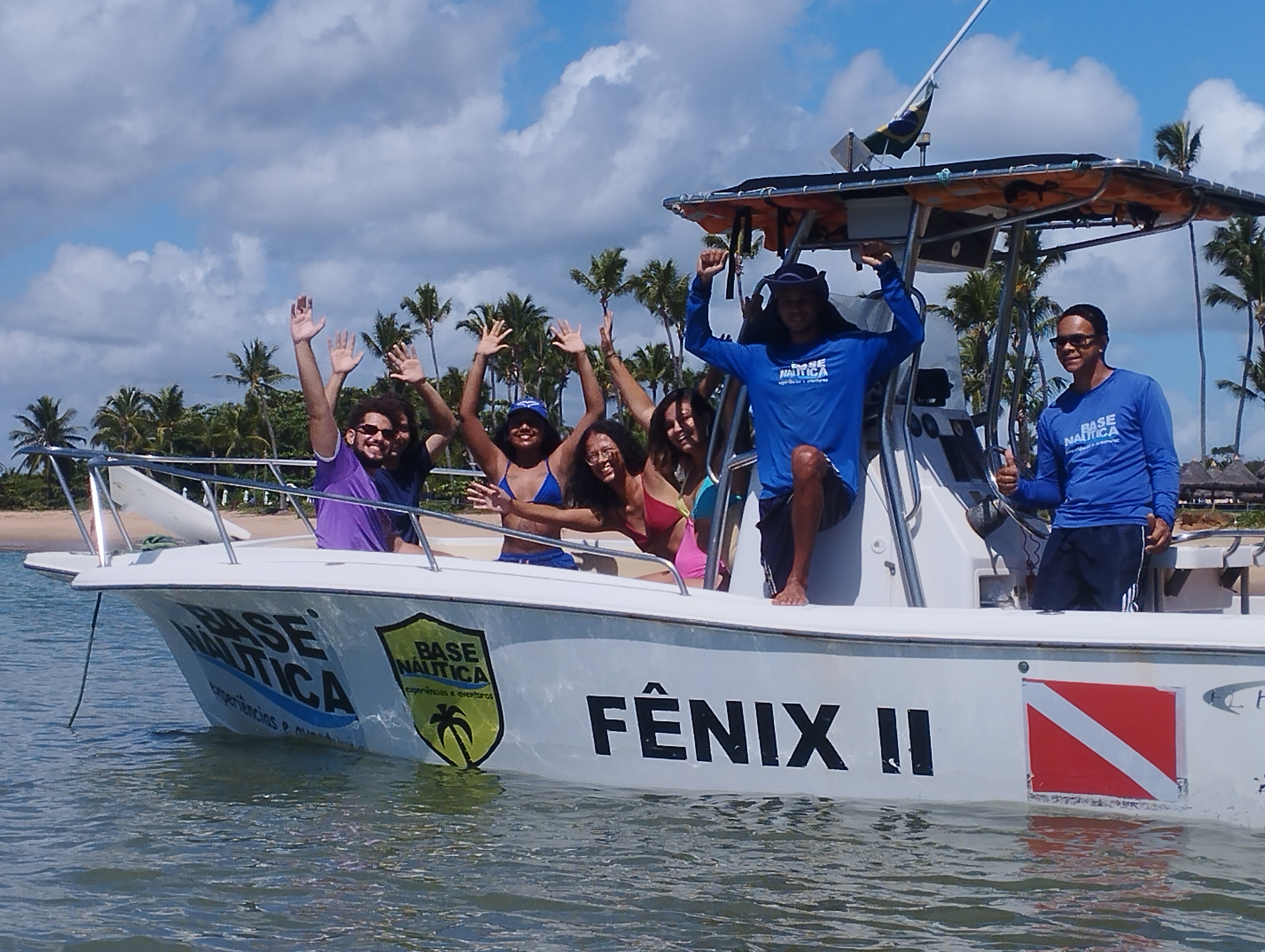 Grupo feliz na lancha Fênix II da Base Náutica em Praia do Forte